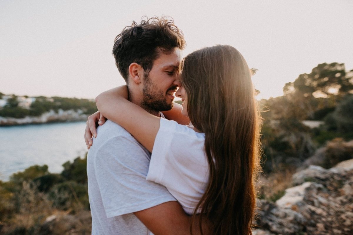 Esposa beijando namorado na praia abraçados