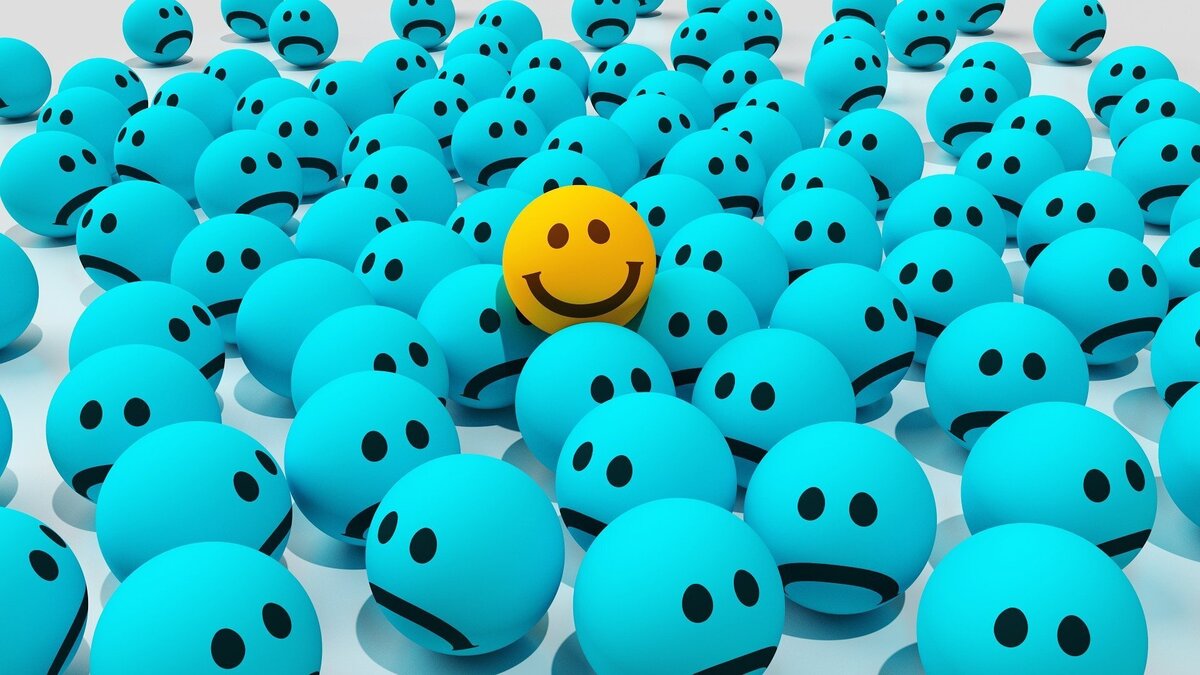 Emoji feliz no meio de vários tristes.