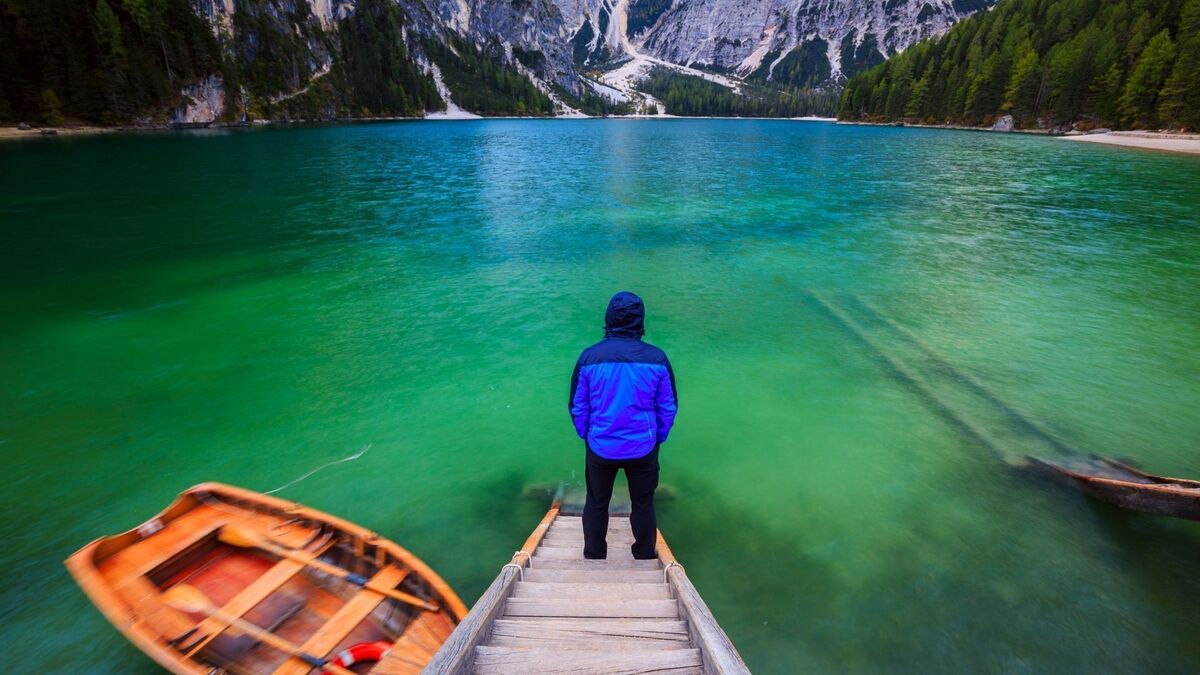 Homem sozinho na frente de um lago.