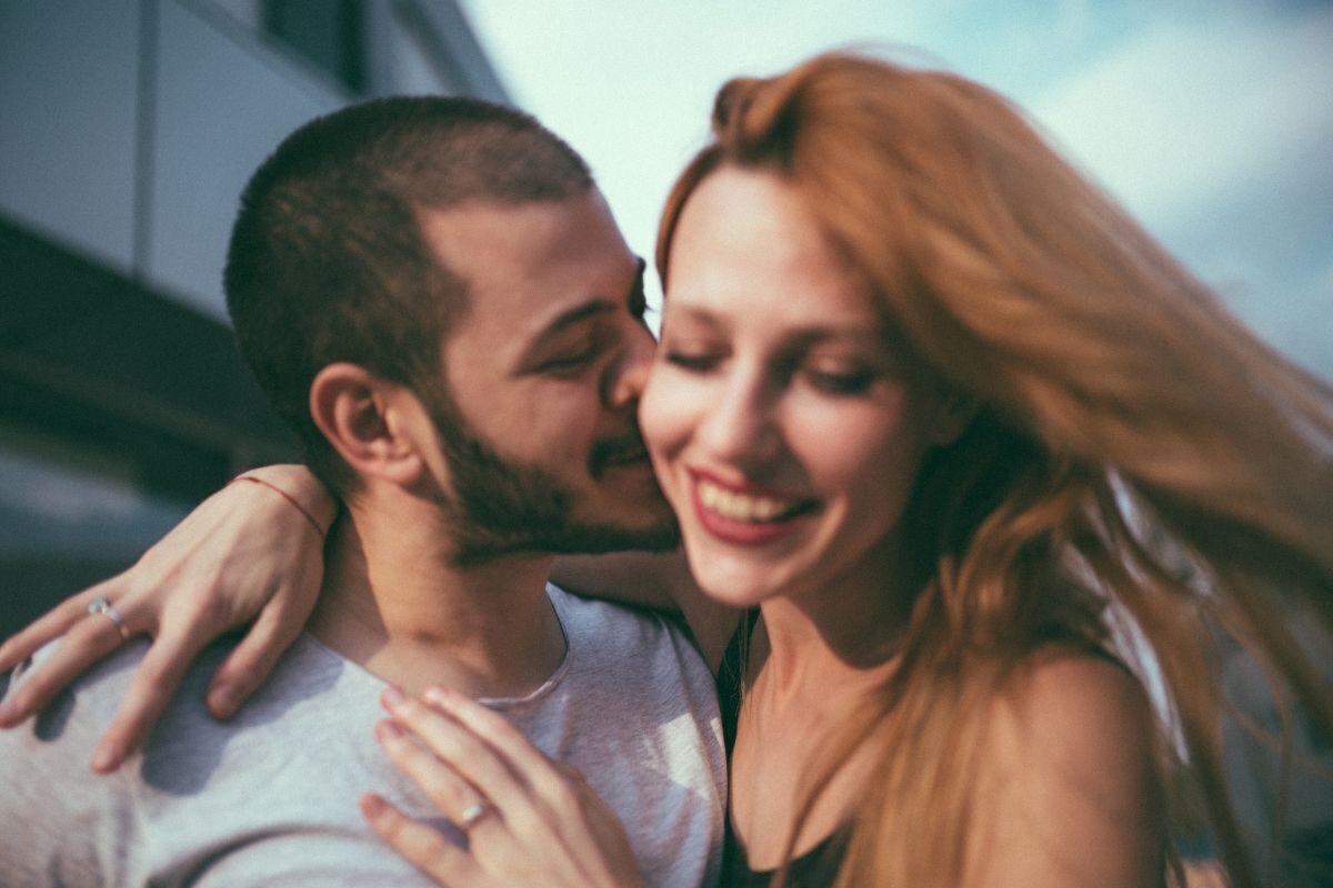 Homem apaixonado beijando a sua namorada no rosto