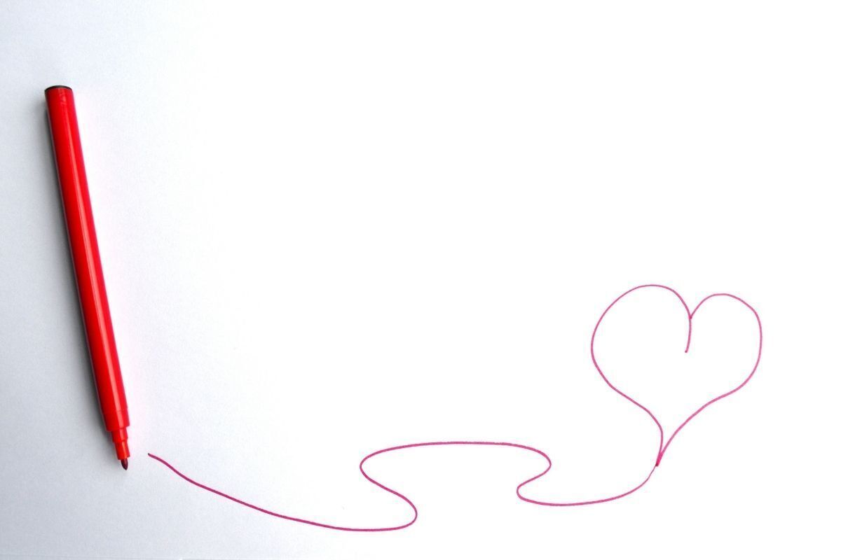 Caneta desenhando um coração em uma folha de papel