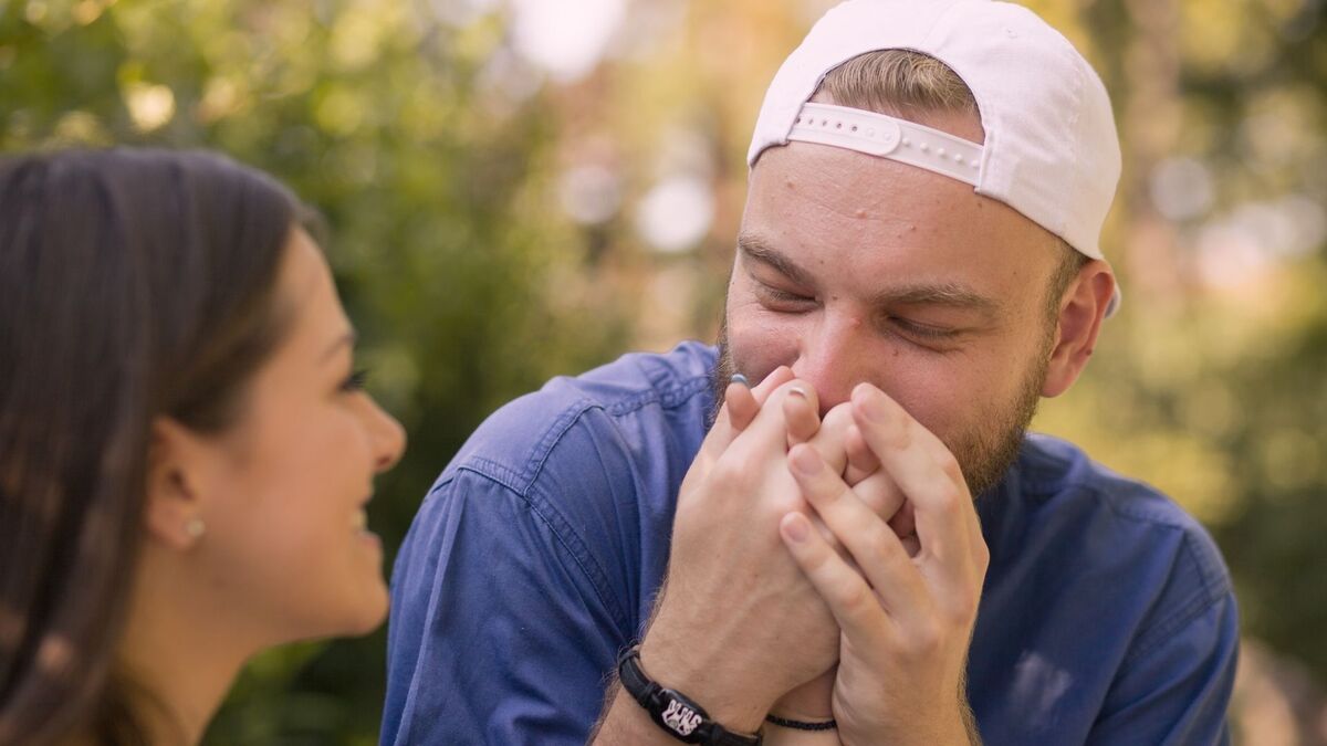 Homem beijando a mão de uma mulher.
