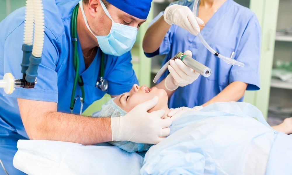 Enfermeiros aplicando anestesia em cirurgia.