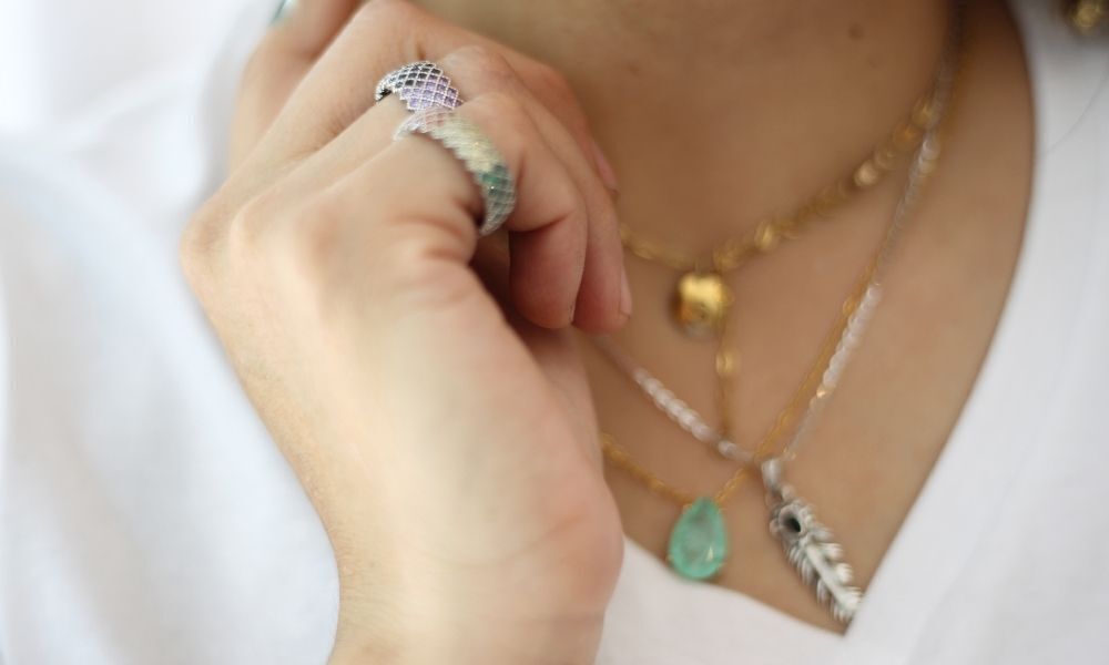 Mulher usando amuleto em colar e anel.
