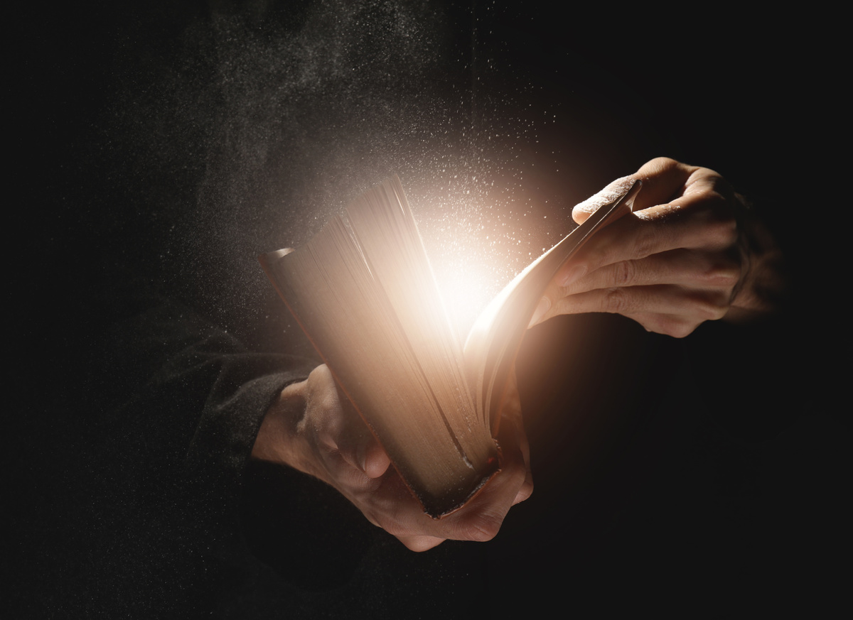 Pessoa abrindo a Bíblia e luz saindo de dentro dela