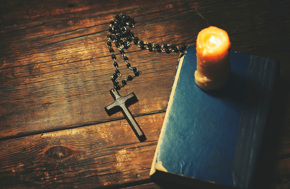 Bíblia com vela acesa ao lado para oração a Santa Rita de Cássia