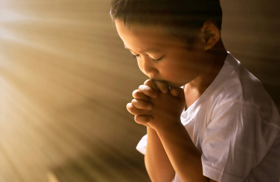 Criança fazendo uma oração para Santa Rita de Cássia