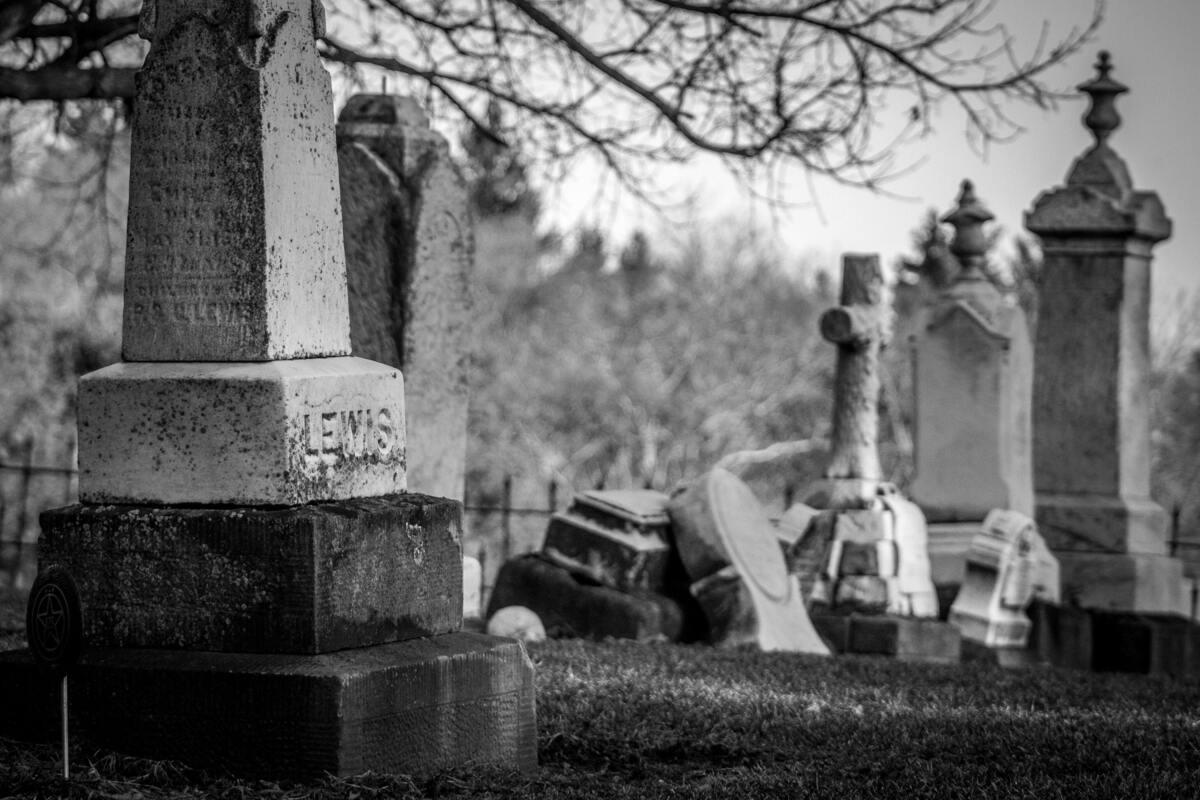 Cemitério com lápides antigas e caídas