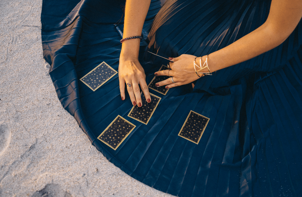 Mãos femininas manuseando cartas do Tarot