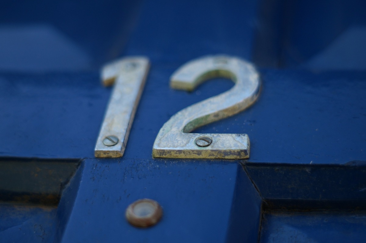 O número 12 em relevo, em meio à porta azul.