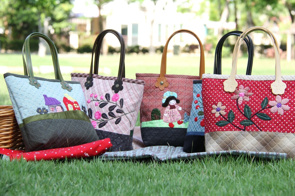 Várias bolsas coloridas com desenhos bordados.
