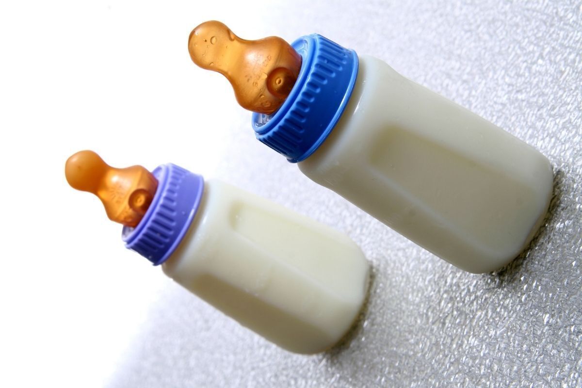 Duas mamadeiras azuis cheias de leite