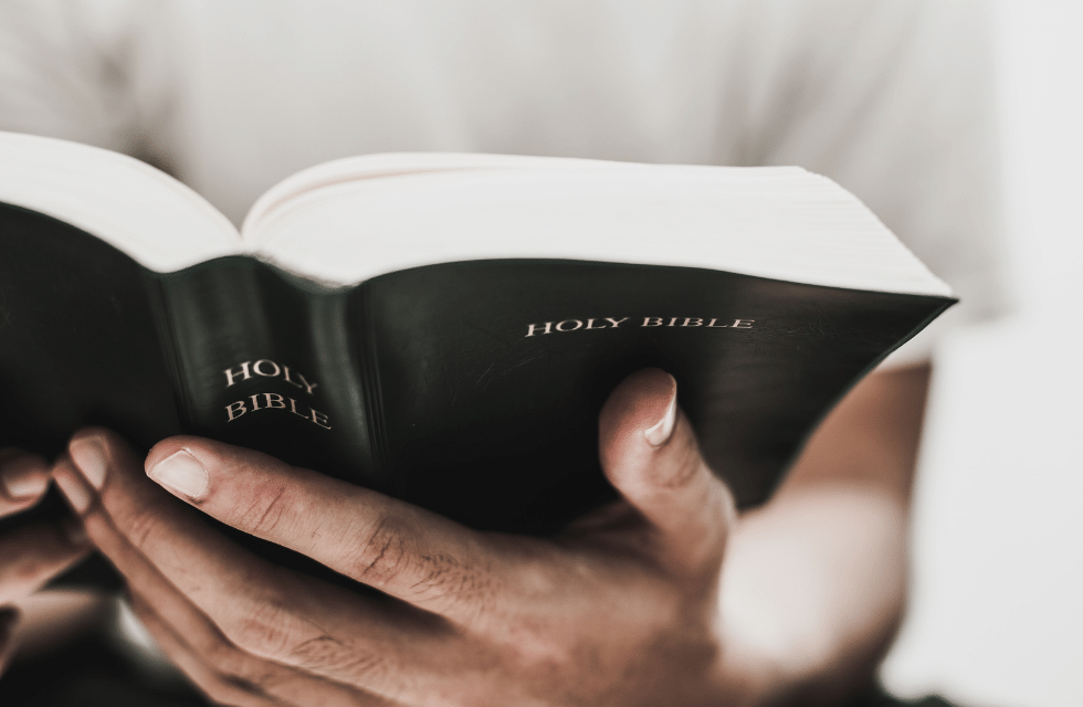 Pessoa com bíblia aberta na mão
