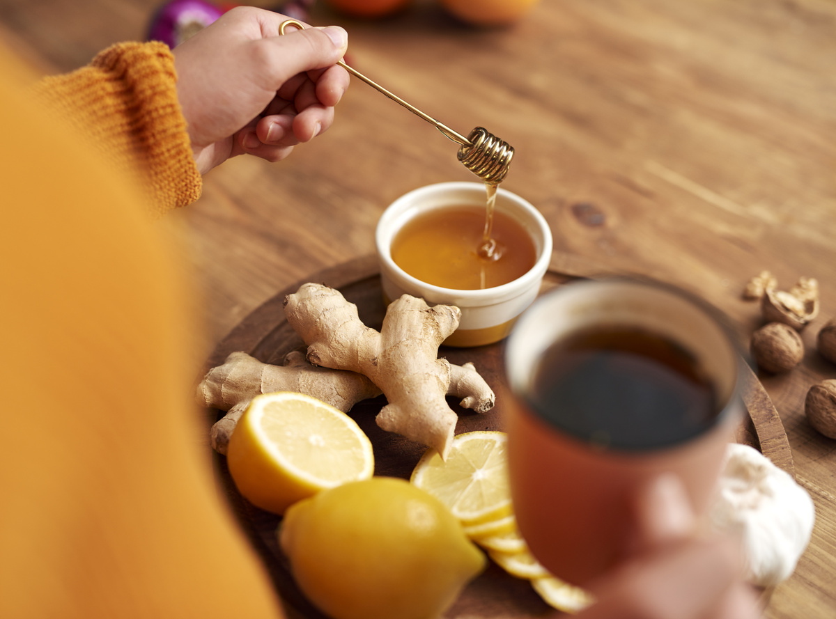 Mulher colocando mel no chá de limão