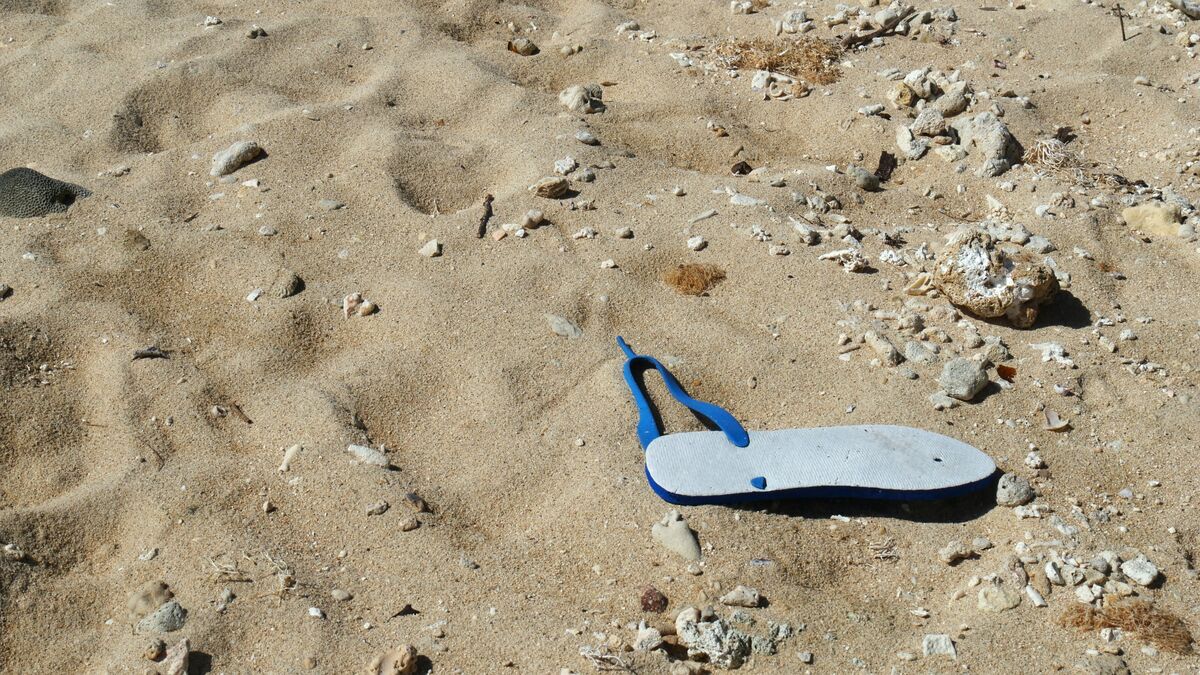 Um chinelo arrebentado na areia