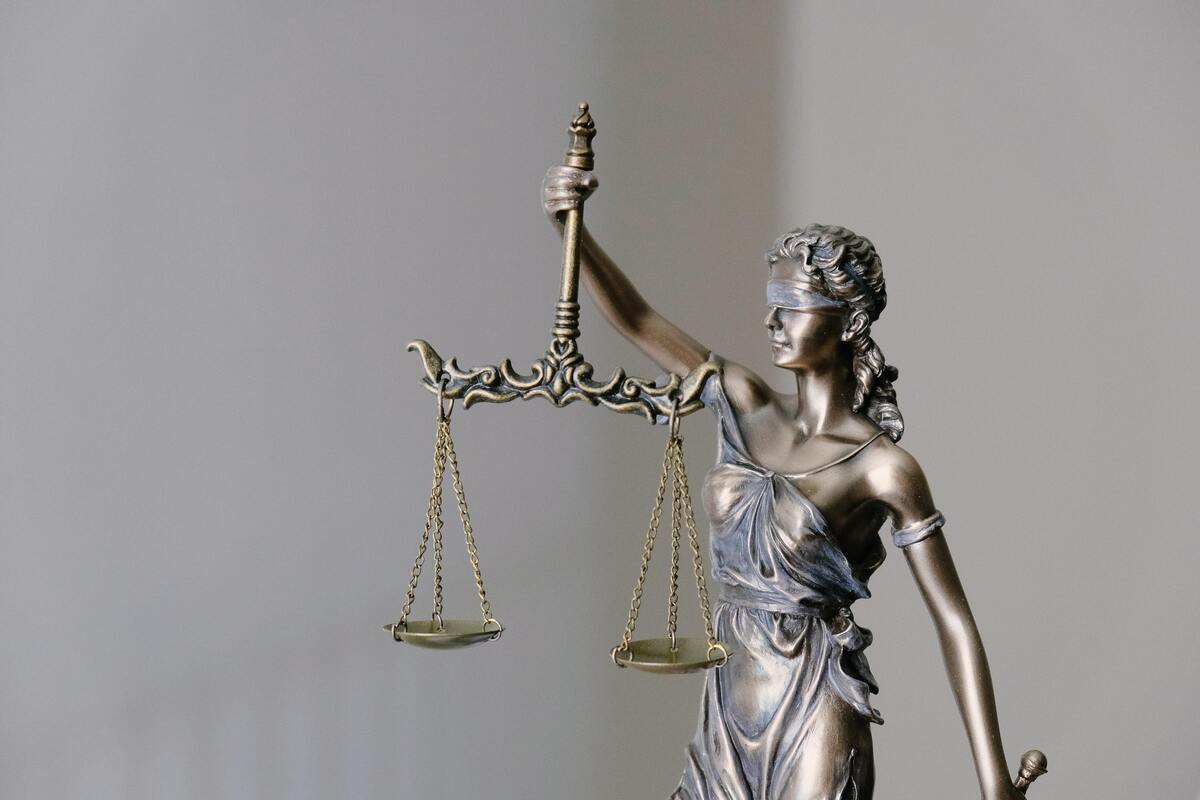 Estátua representando a justiça com uma mulher de olhos vendados segurando uma balança