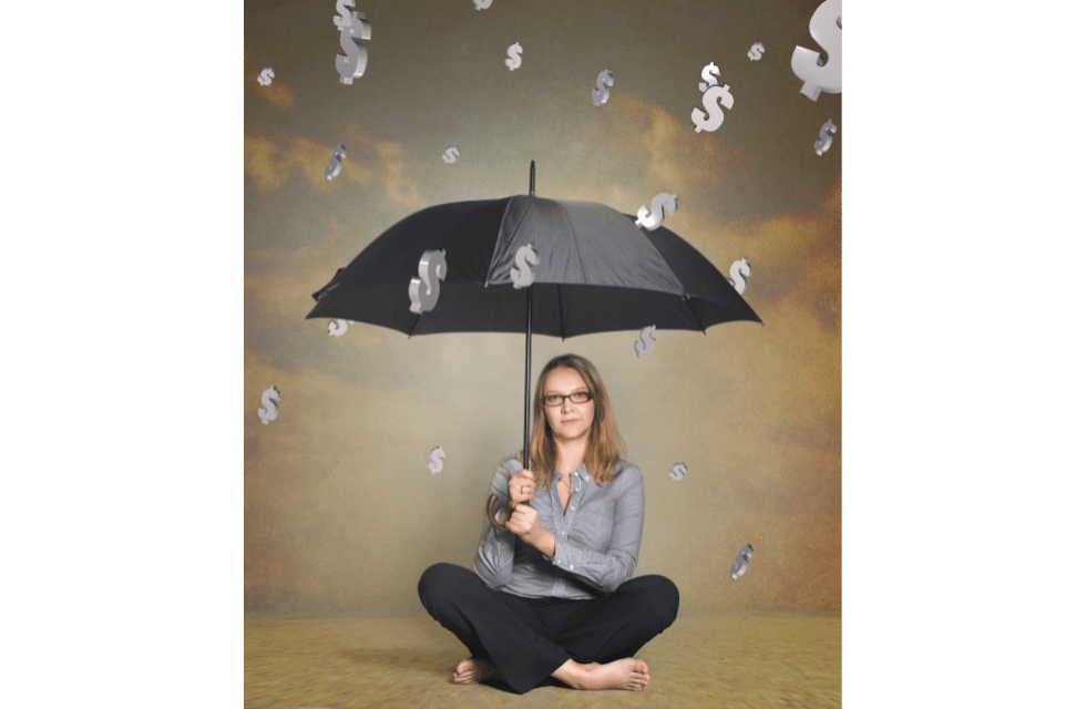 Mulher com guarda-chuva se protegendo de uma chuva de dívidas
