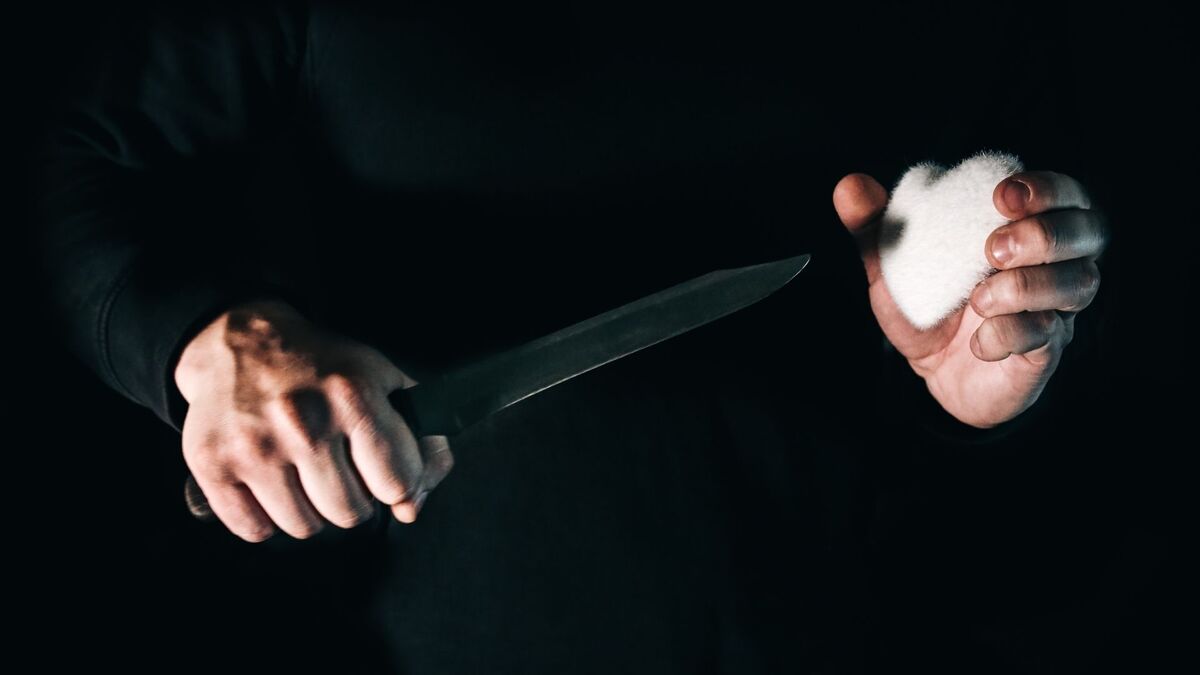 Homem de preto com uma faca.