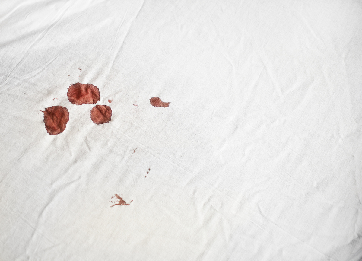 Lençol branco manchado por gotas de sangue. 