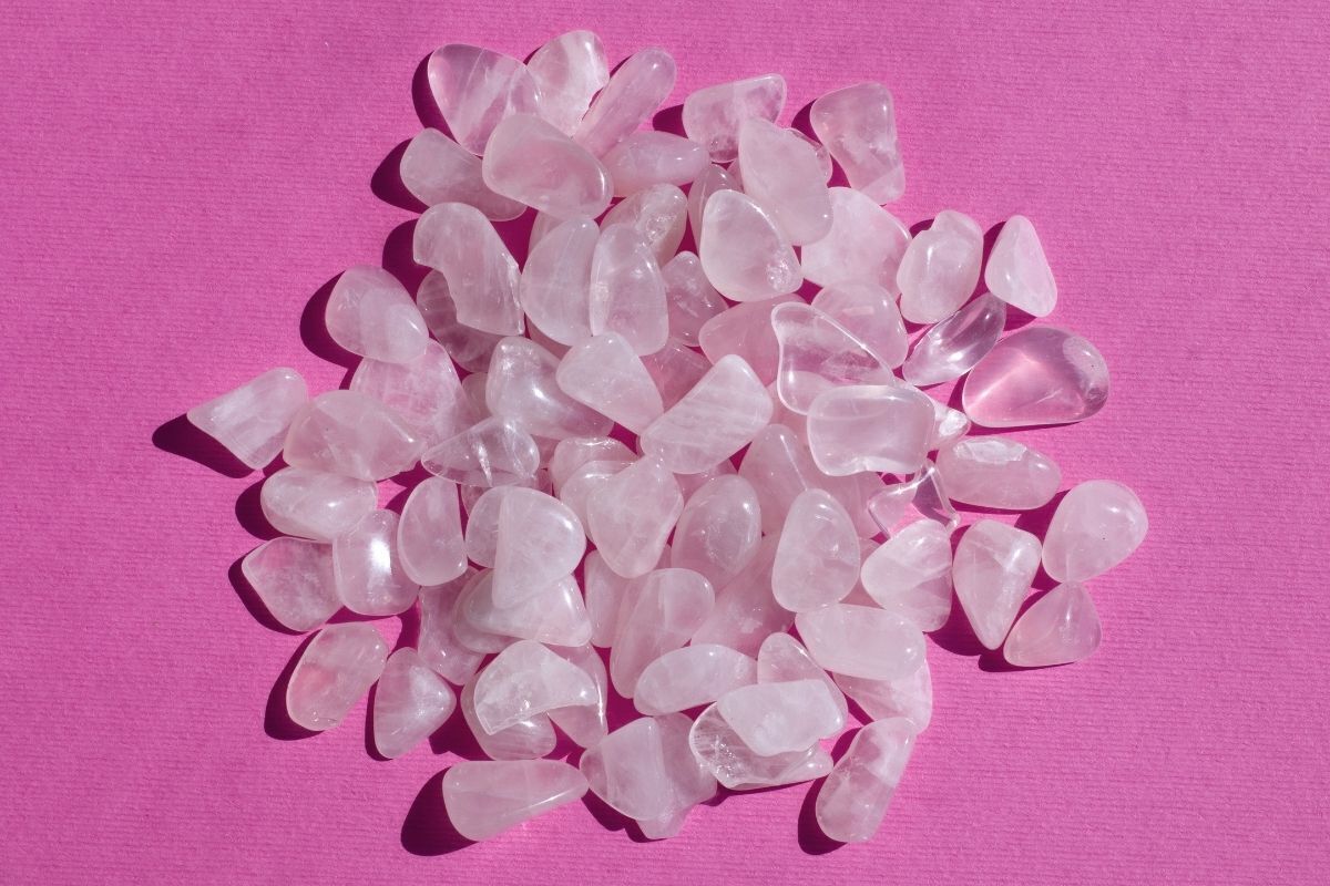 Pedras médias de cristais de quartzo rosa sob uma superfície pink