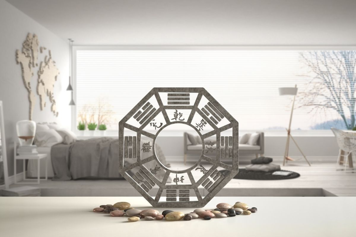Prateleira de mesa branca com baguá e pedra seixo, sala branca com grande janela panorâmica, design de interiores com um conceito zen, ideia de modelo feng shui
