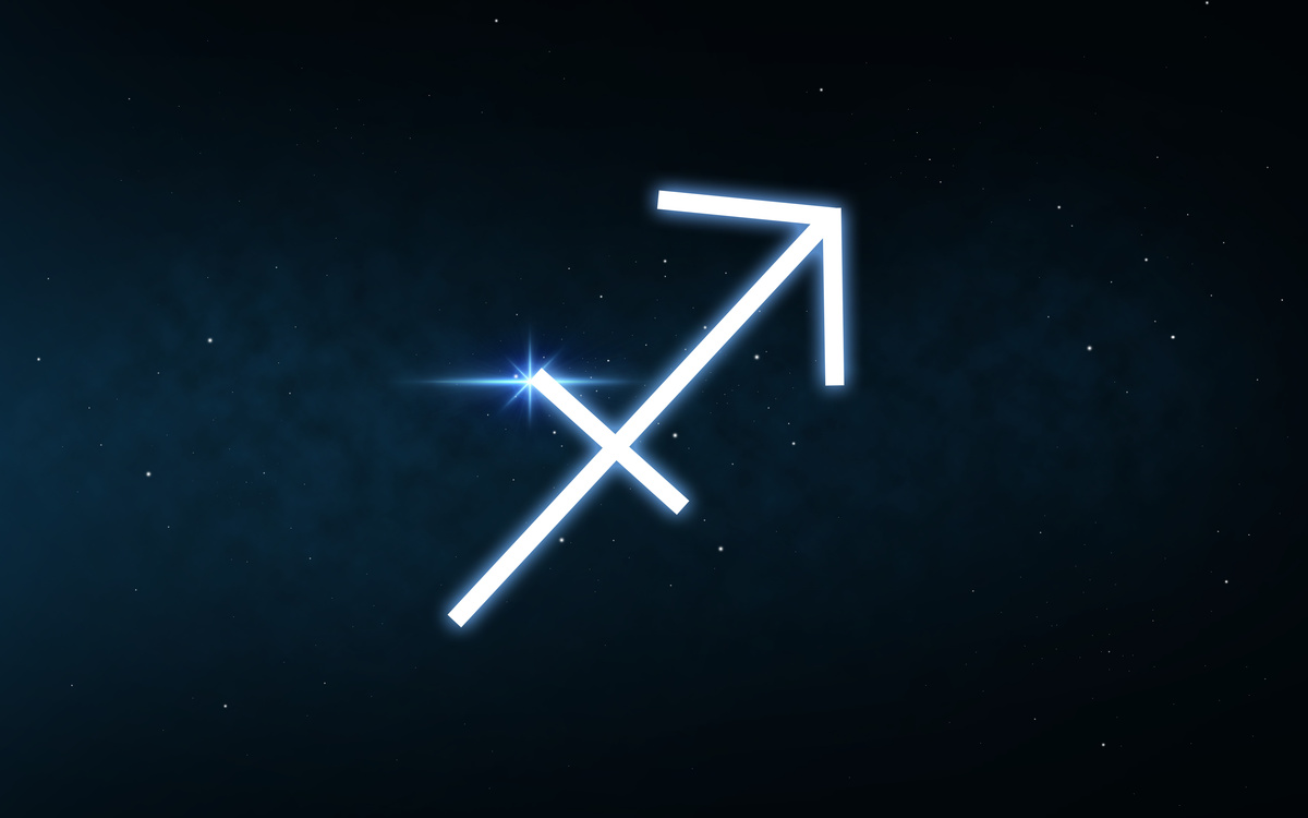 Flecha, símbolo do signo de Sagitário, desenhada em cenário de céu cheio de estrelas, 