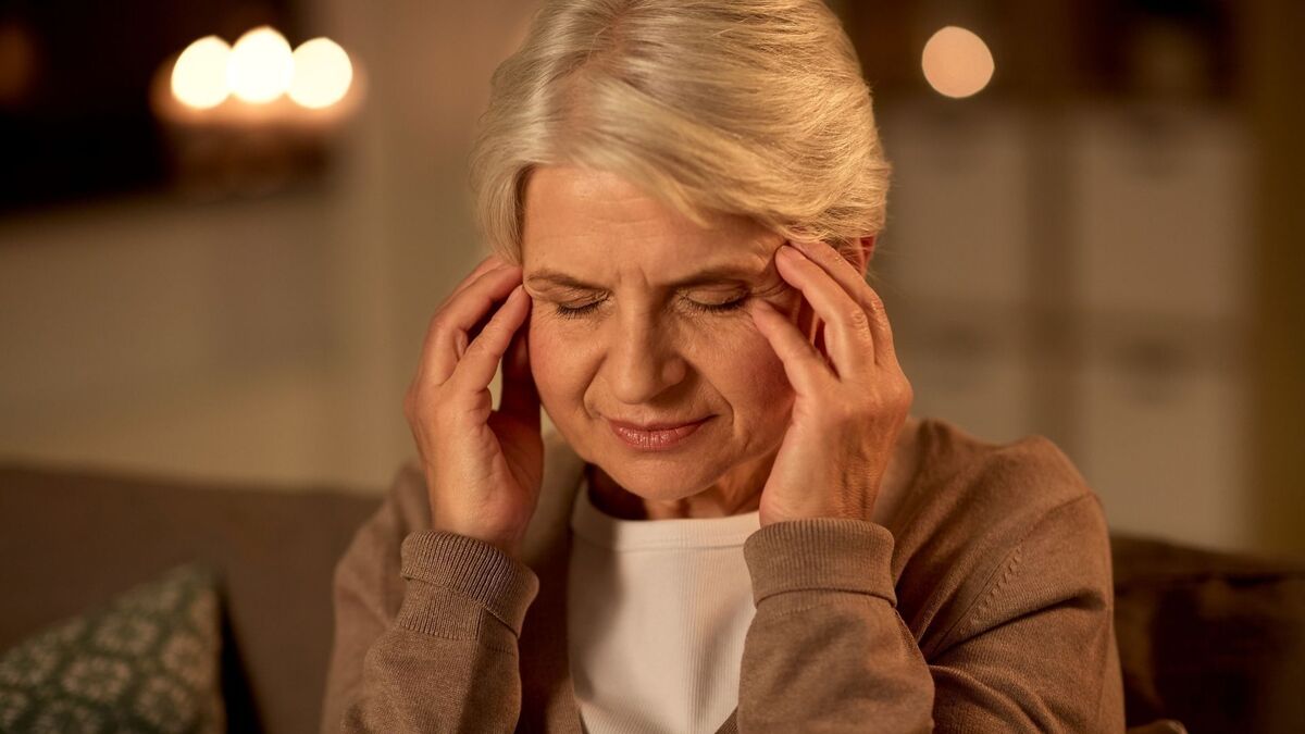 Mulher idosa com dor de cabeça.