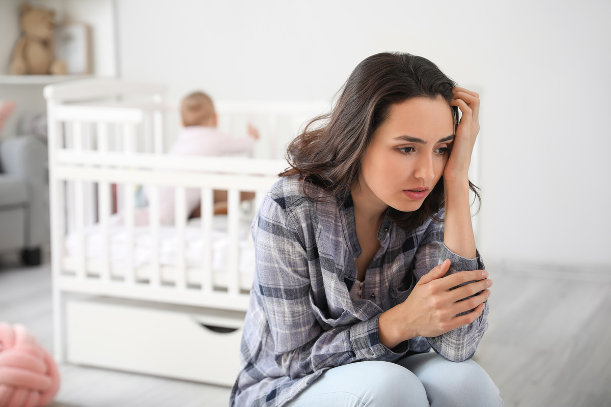 Mulher com depressão pós-parto do quarto do bebê