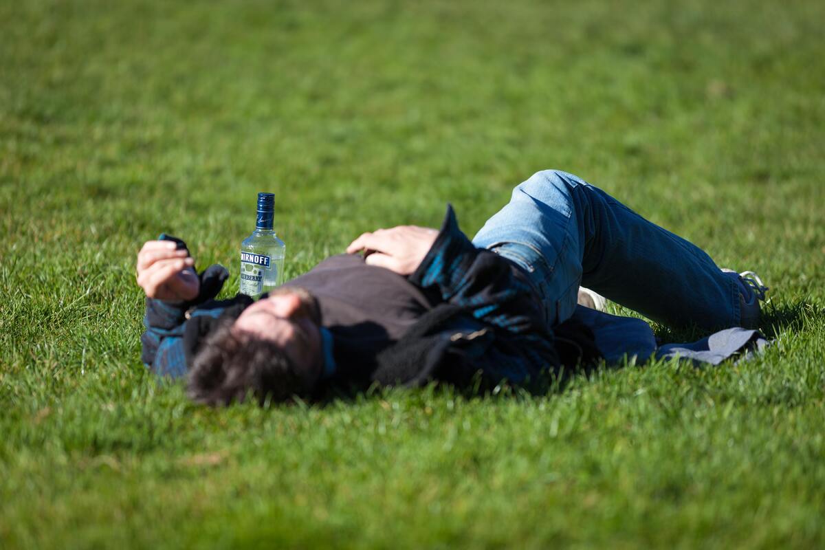 Homem deitado em um campo gramado.