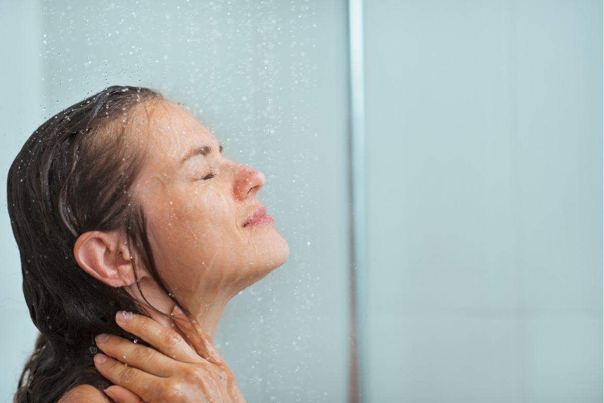 Mulher tomando uma ducha. 
