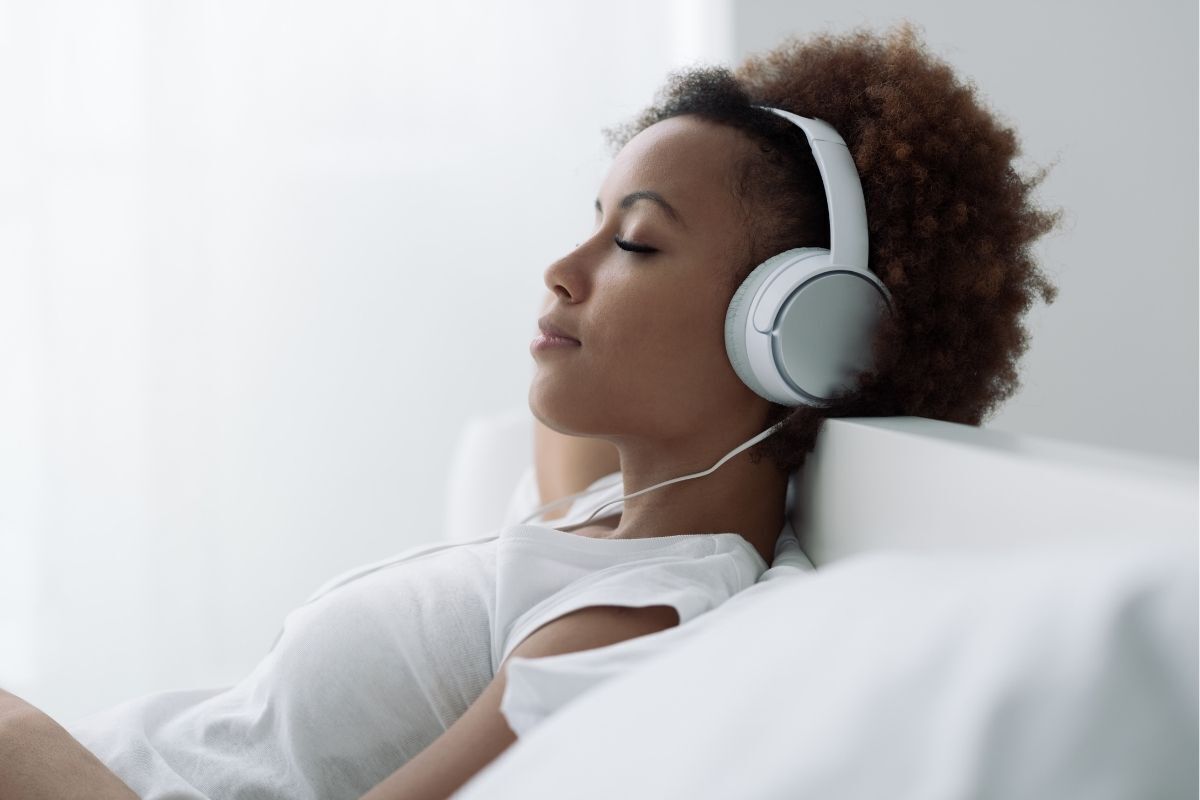 Mulher ouvindo música relaxante com um fone de ouvido