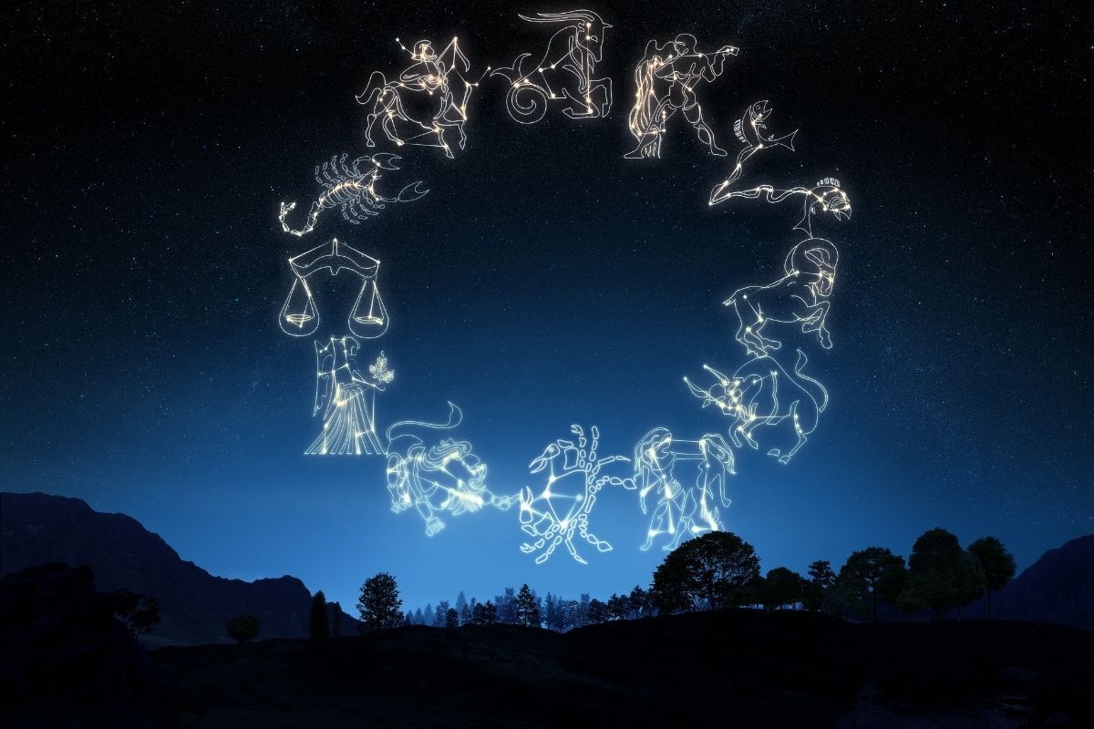 Ilustração dos signos do zodíaco, ilustrados em neon no céu de um um anoitecer no campo