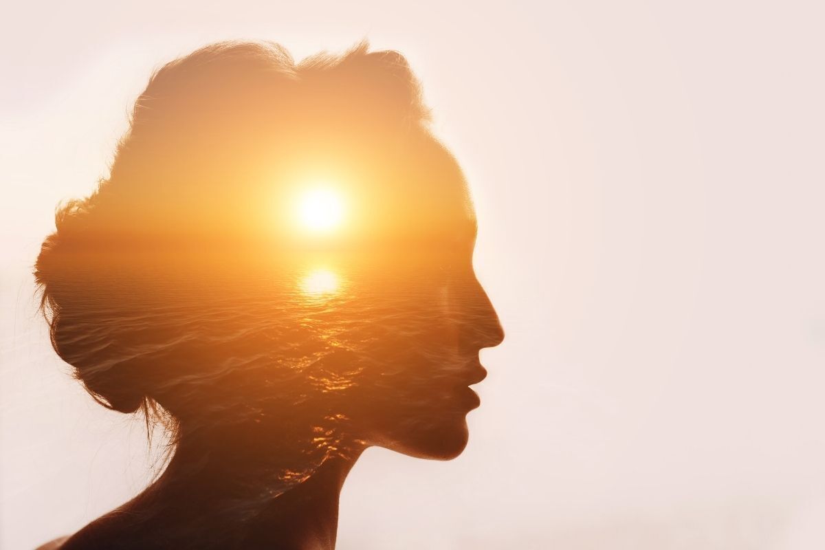Imagem ilustrativa, representando a filosofia com a silhueta do perfil do rosto de uma mulher. Nela, há a imagem do sol brilhando no mar.