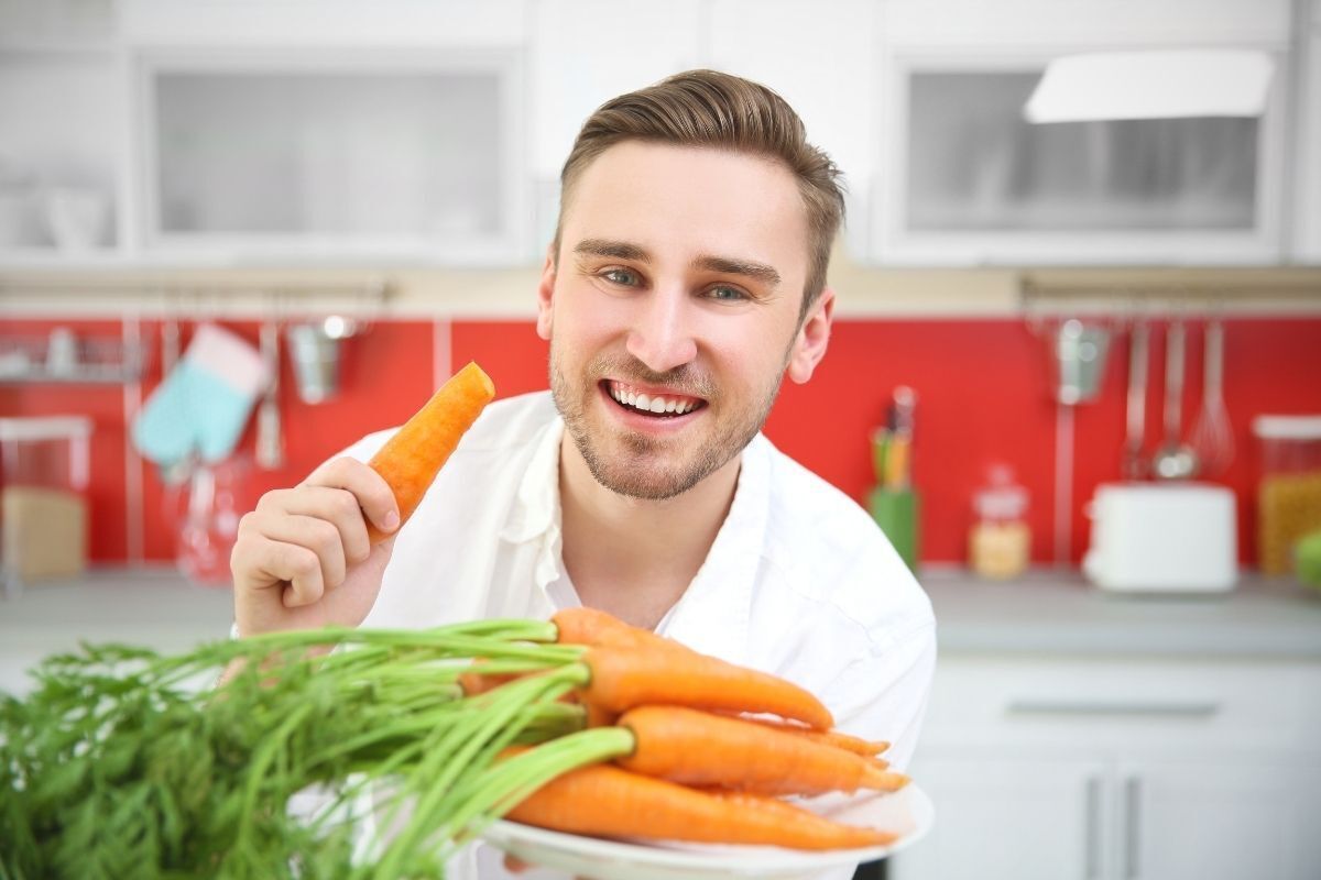 Homem comendo cenoura.