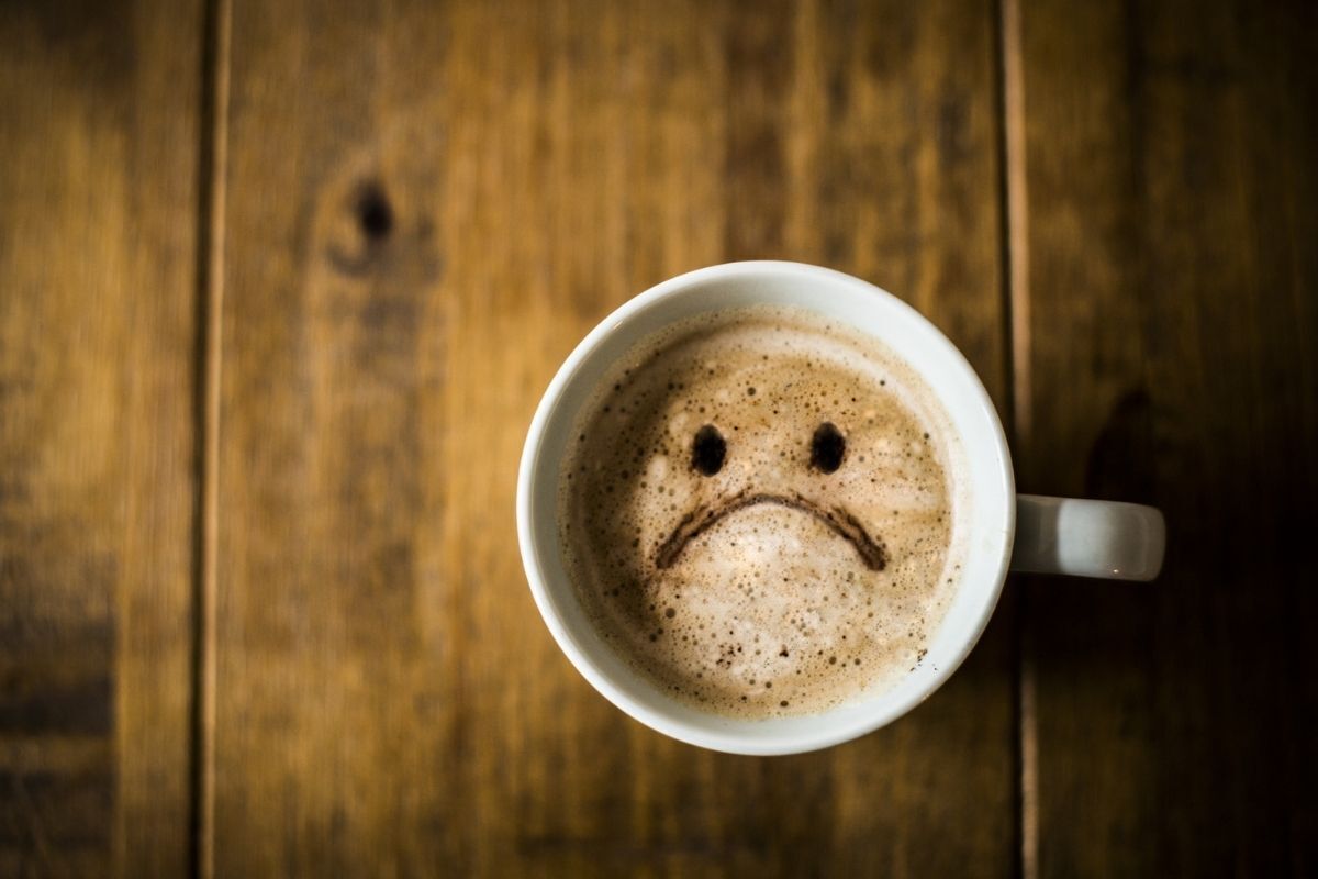 Ilustração - emoji de tristeza desenhado no café 