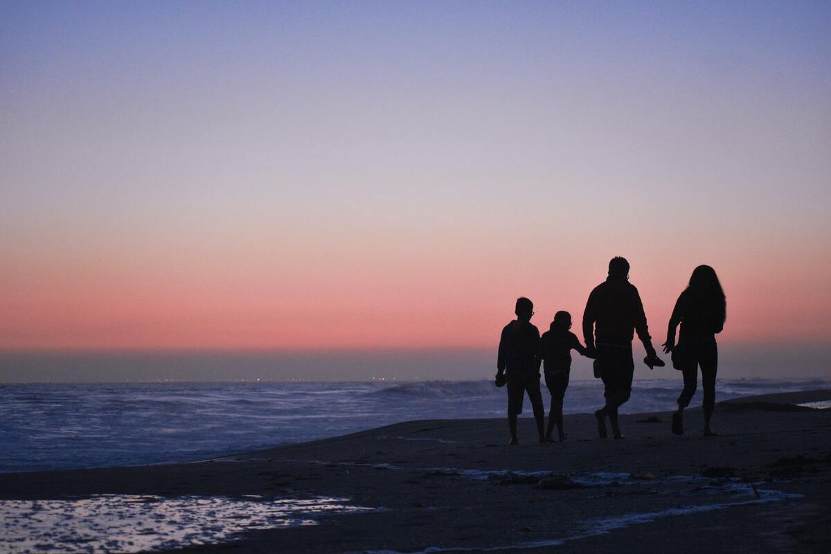 Família andando na praia.