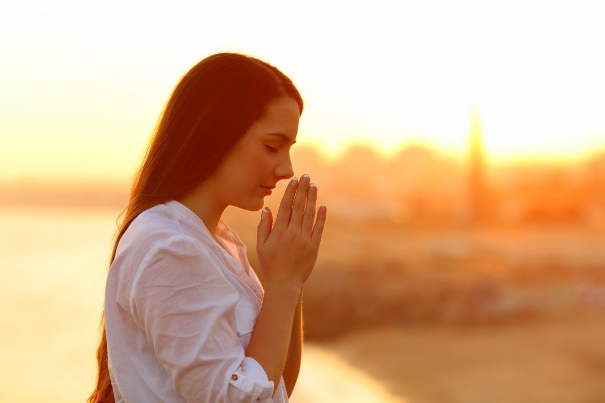 Mulher fazendo oração de gratidão
