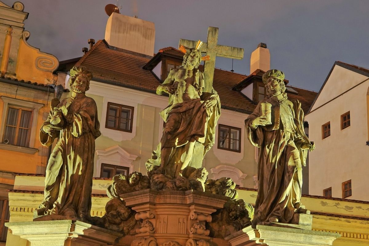 Estátua do Santo Salvador com Cosme e Damião na Ponte Carlos em Praga, República Tcheca, por Jan Oldrich Mayer à noite.