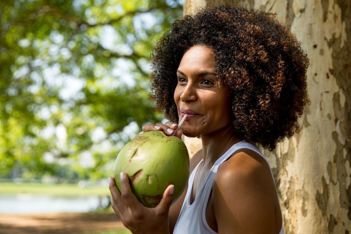 Mulher bebendo água de coco