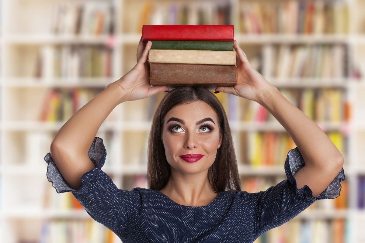Imagem de uma mulher inteligente, carregando livros em cima de sua cabeça