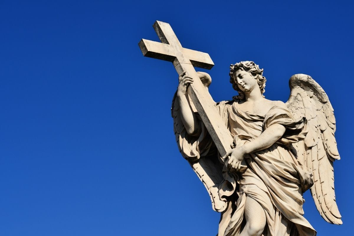Estátua de um anjo segurando uma cruz