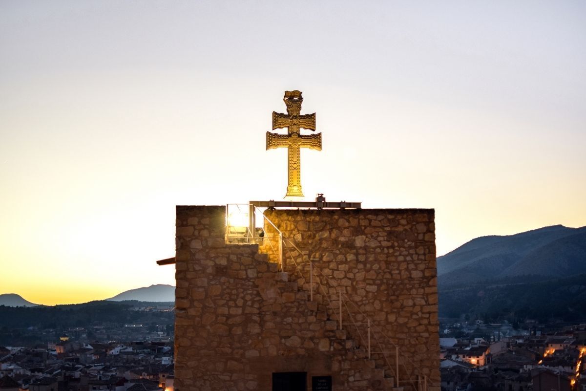 Antiga cruz cristã contra a paisagem urbana de Caravaca, Espanha.