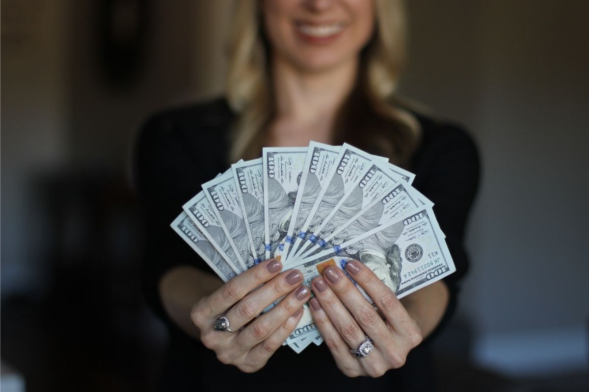 Mulher segurando muitas notas de dinheiro