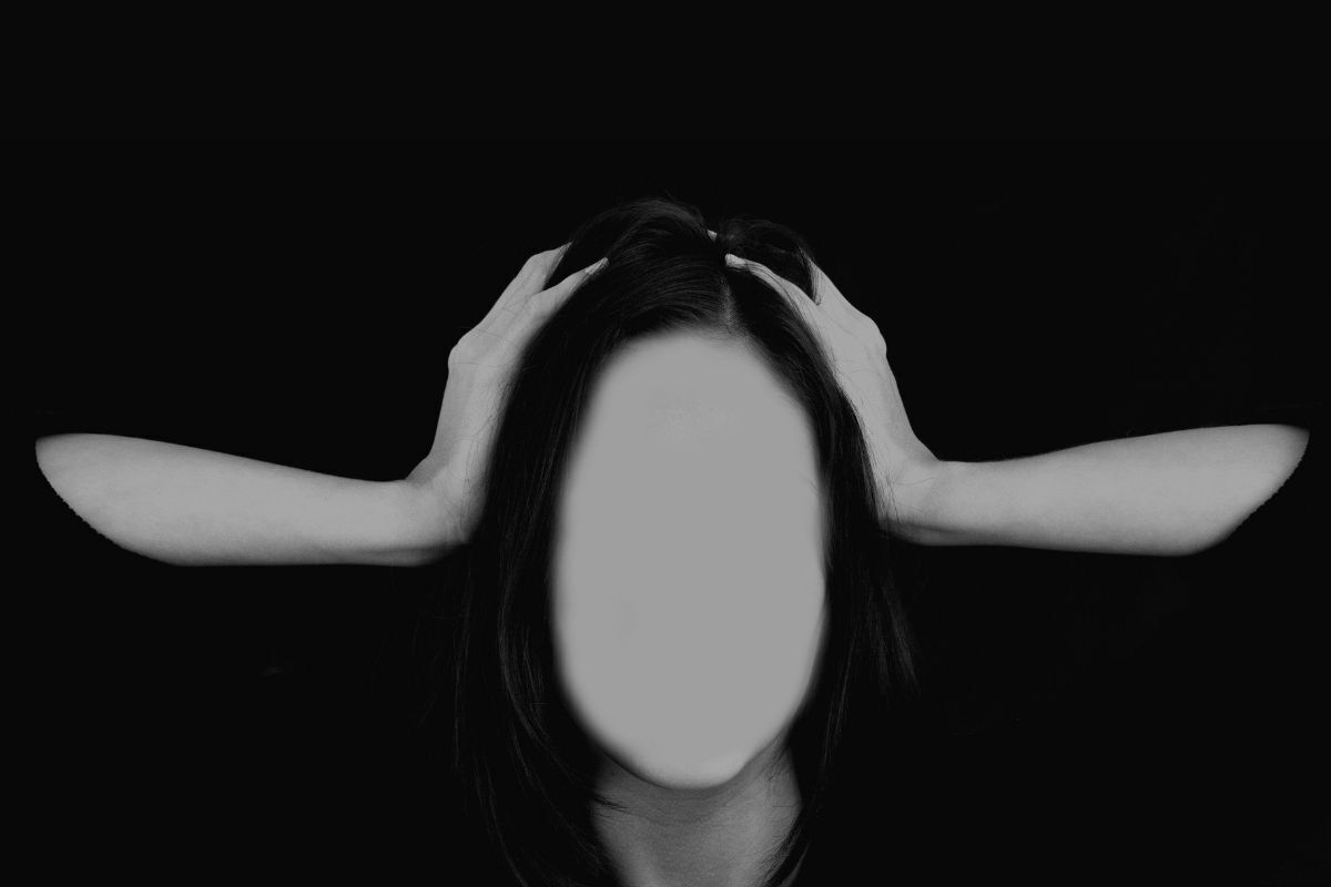 Crise existencial - ilustração da imagem com uma mulher com o rosto apagado, desesperada com as mãos na cabeça