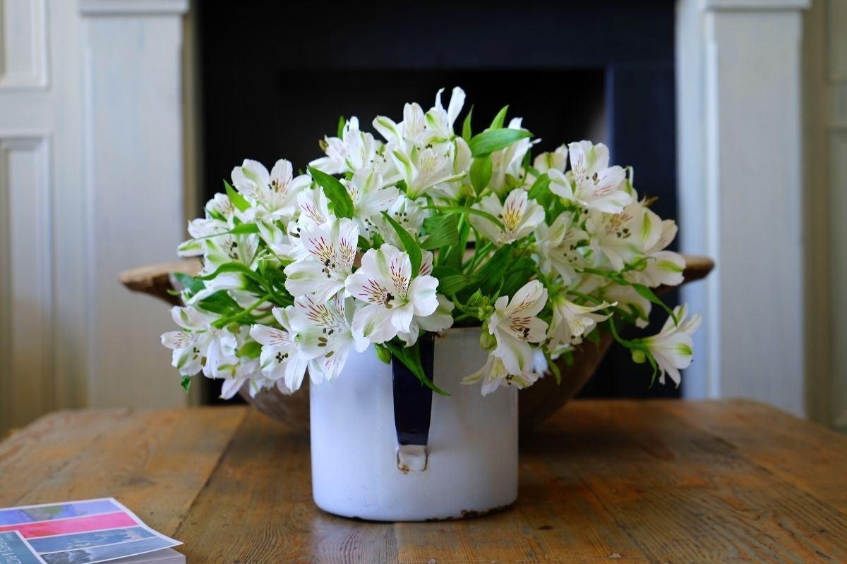 Vaso de flores brancas em uma mesa de madeira
