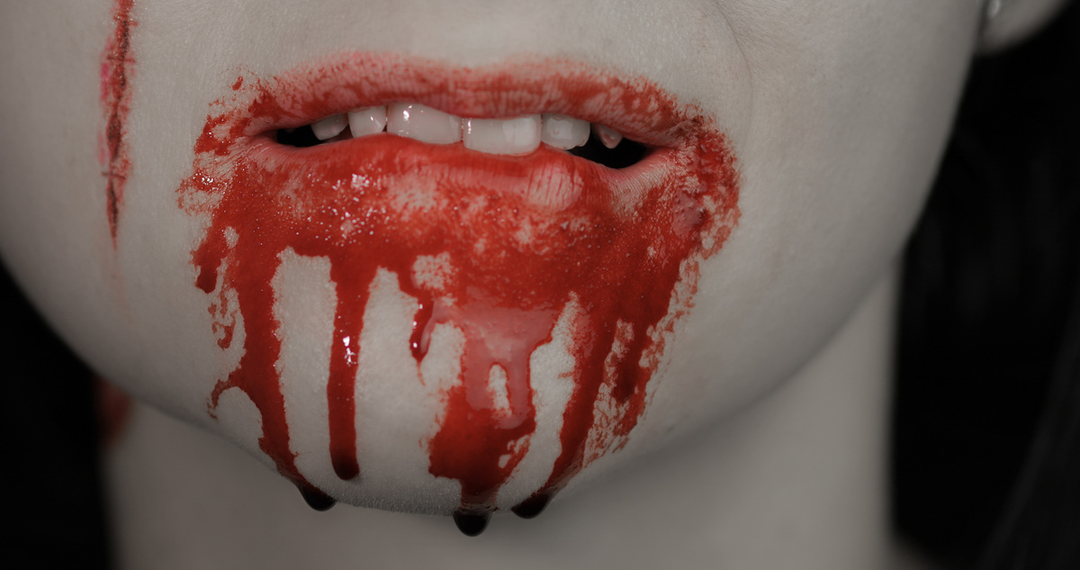 Mulher com a boca suja de sangue após cometer canibalismo