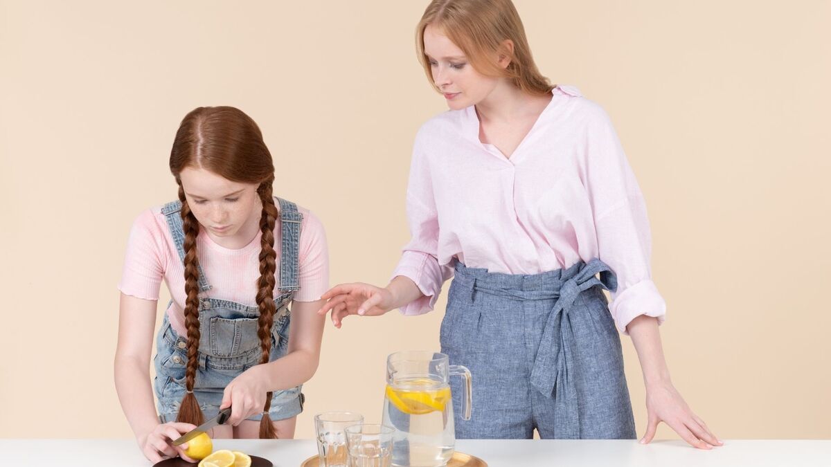 Menina e a mãe misturando água com limão.