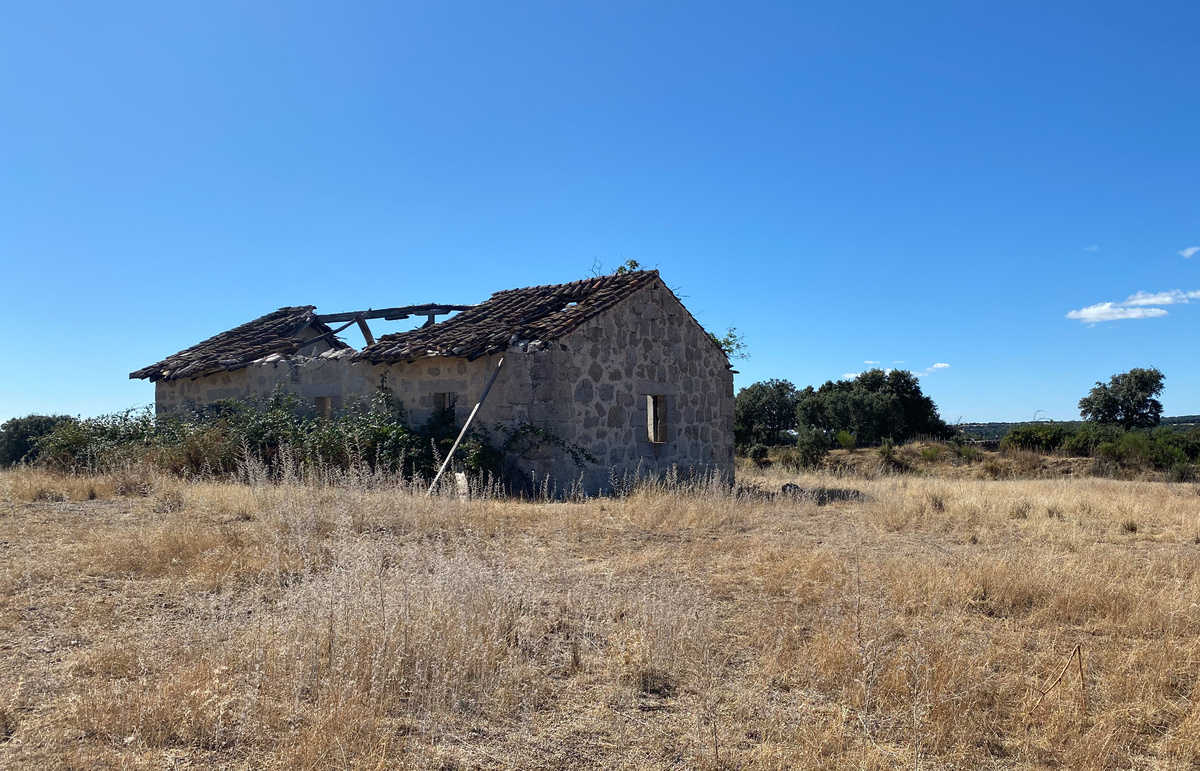 Casa abandonada sem telhado em pasto