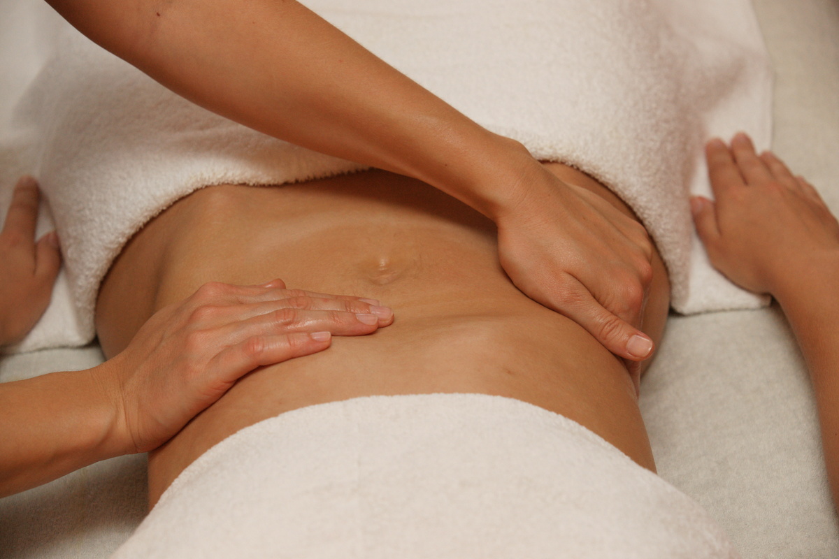 Barriga feminina sendo massageada durante massagem tântrica