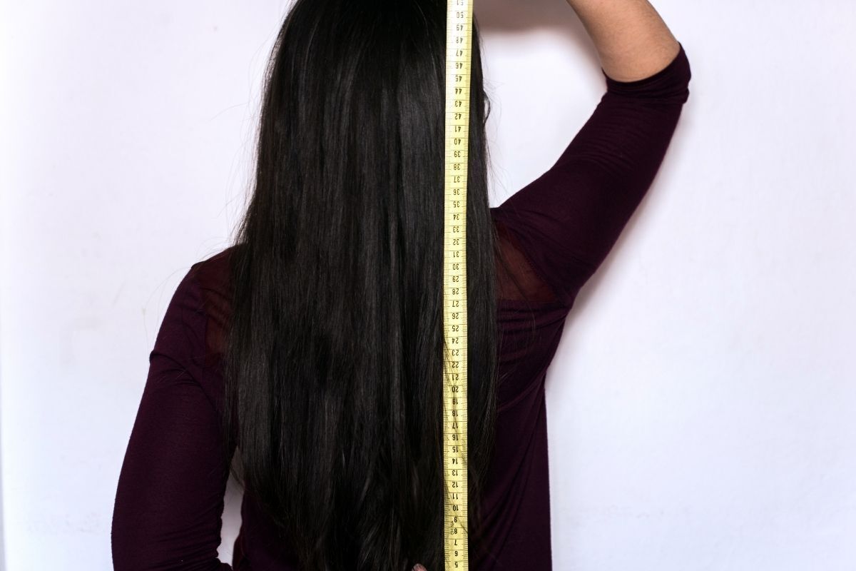 Mulher medindo o comprimento dos cabelos